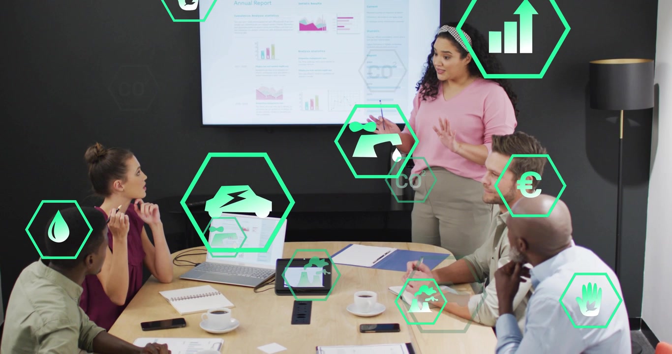 Apresentador apontando para o display e ativando ícones hexagonais verdes visualizando métricas de sustentabilidade.