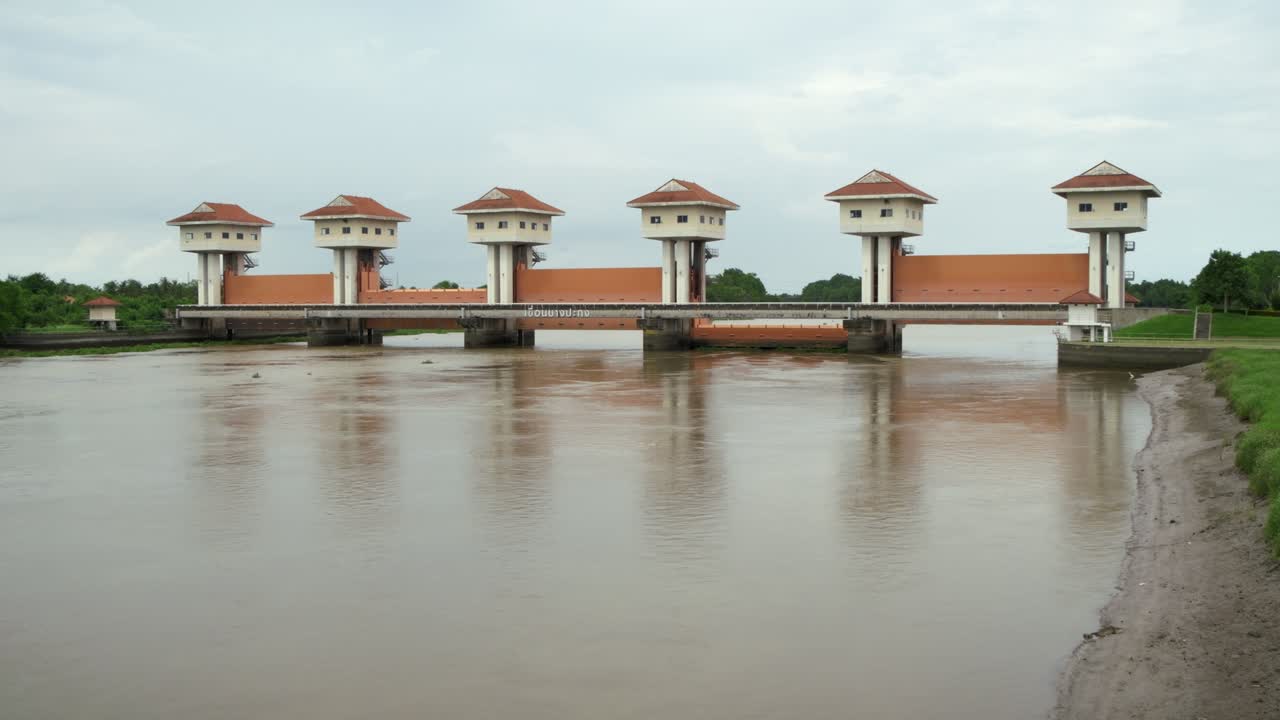 Discover the harmony of engineering and nature as a stunning water control structure complements the tranquil river landscape