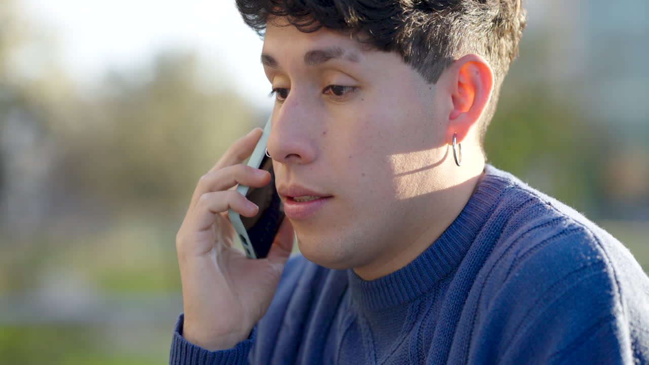 Young man talking on smartphone in park