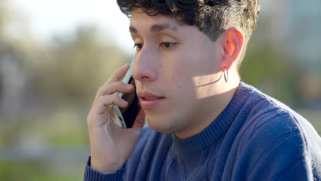 young man talking on smartphone in park