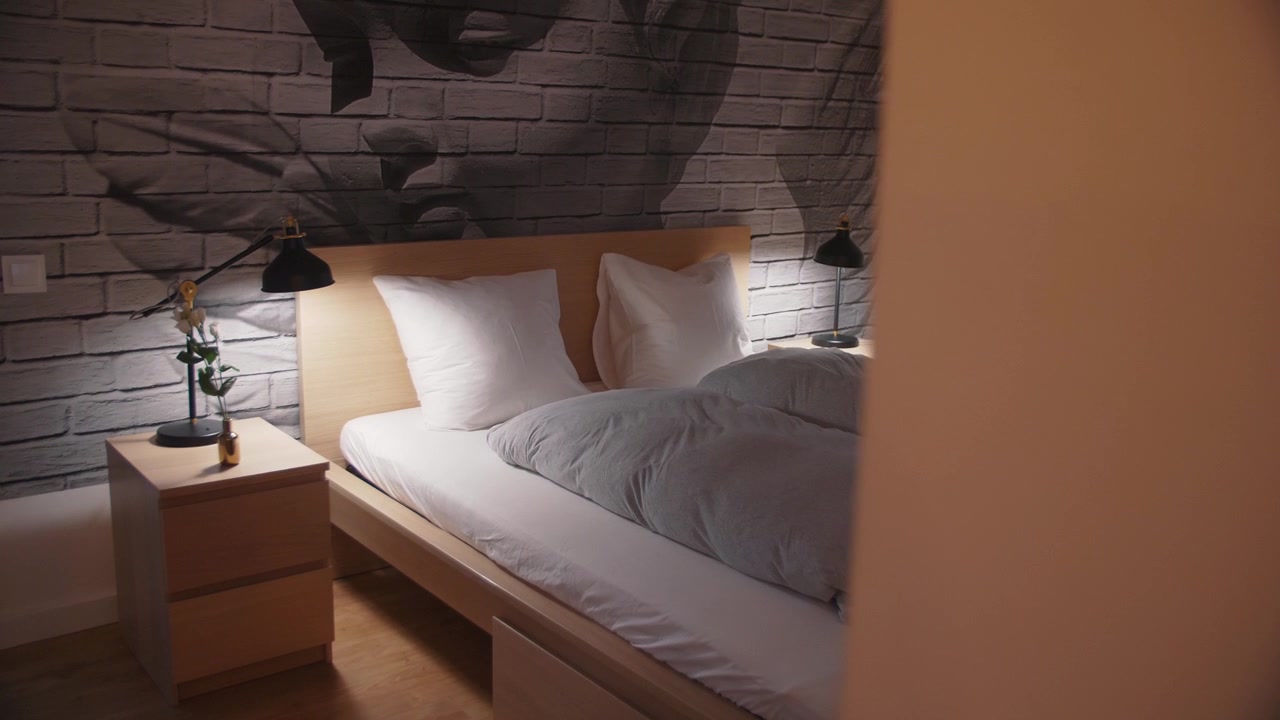 Cozy bed in an Airbnb holiday flat with an interesting painted wall and beautiful interior design.