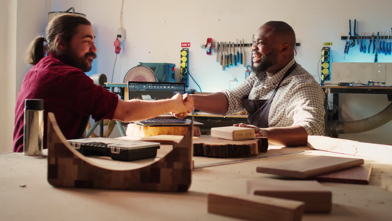 Jolly cabinetmaker and colleague talking in joinery