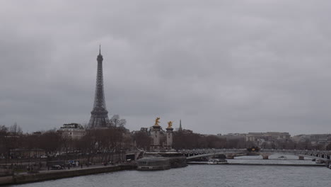 la conocida torre eiffel con el puente alejandro iii que atraviesa el río sena en parís, francia
