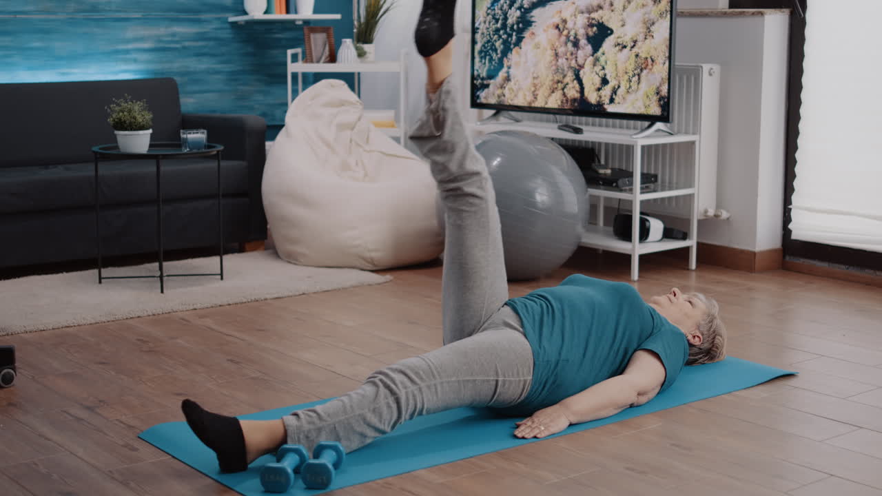 Elder adult raising legs to do physical exercise and workout