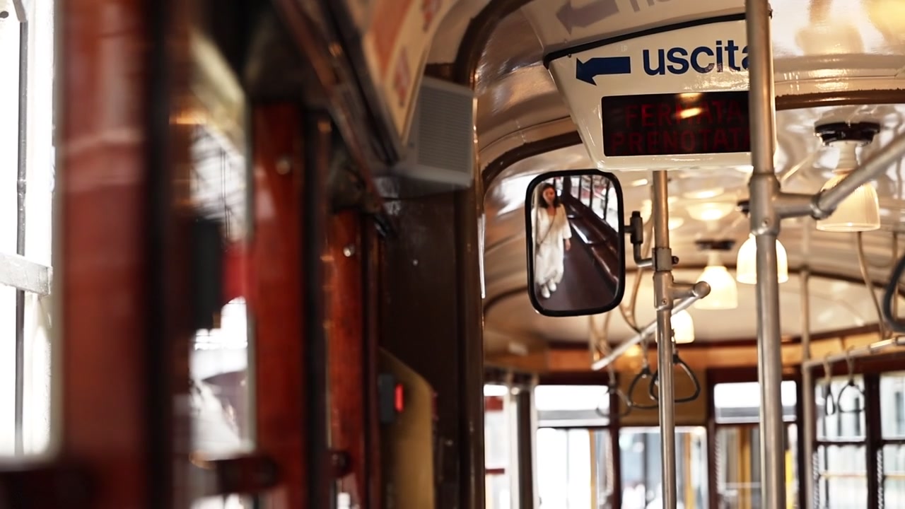 Vrouw drukt op de stopknop in een vintage tram.