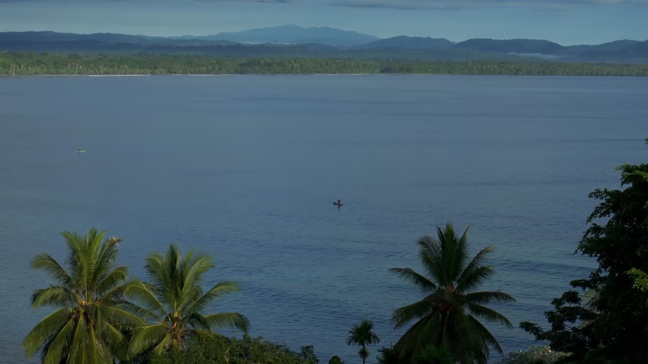 Bilum canoe fishing rboat Coastal town Wewak Papua New Guinea PNG aerial drone Wewak Hill Boram road neighborhood coastline coconut trees Harbor view Dogreto Bay Cape Wom morning blue sky forward pan