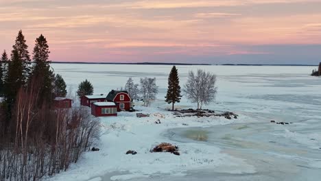 casas rojas enclavadas en un paisaje nevado al anochecer, bahía de bothnian cerca de luleå, suecia, escena de invierno serena, vista aérea