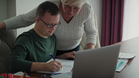 Man-with-down-syndrome-learning-with-his-mum-at-home