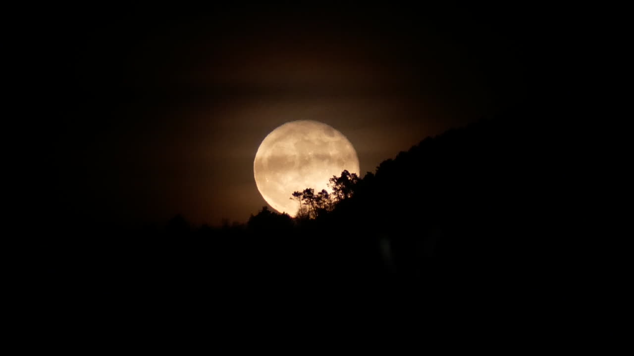 Lua cheia nascendo em julho de 2017, na paisagem rural da Toscana, Itália.