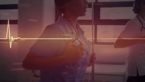animation of heart rate monitor over diverse female doctor and health worker running in hospital