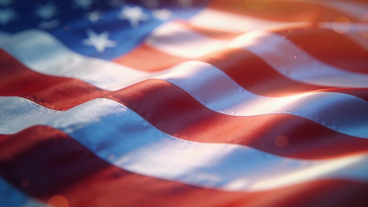Bølgende amerikansk flagstof, der blafrer i en let brise, i et gyldent nærbillede, der viser tekstur og flagets struktur.