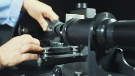 man adjusts the focus of the gun scope in the laboratory