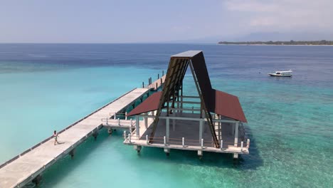 Mädchen,-Das-Bei-Sonnenlicht-über-Einen-Holzsteg-über-Dem-Kristallklaren-Wasser-Des-Wunderschönen-Indischen-Ozeans-Geht