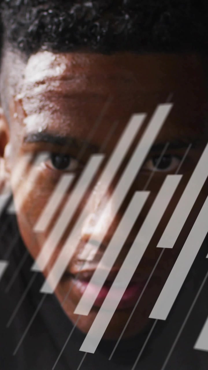Vertical video: Man holding gaze in gym ad, breathing causing diagonal bars over face showing sweat