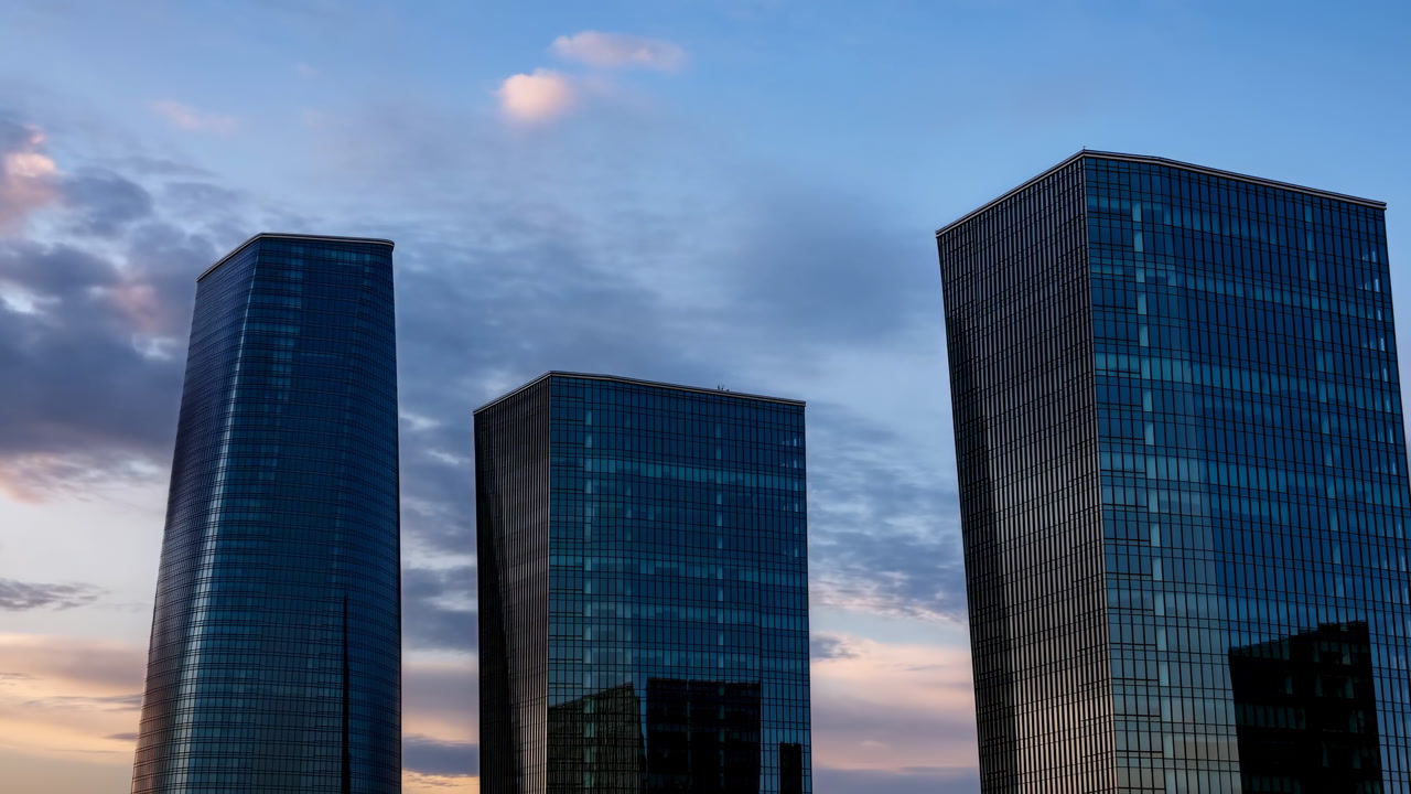 Dusk Glass Towers Reflect Soft Sky, Three Mirrored Skyscrapers Rise In Calm Financial District With Cool Blue