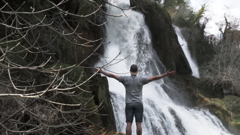 Young-Traveler-standing-in-front-of-Edessa-waterfall-in-greece