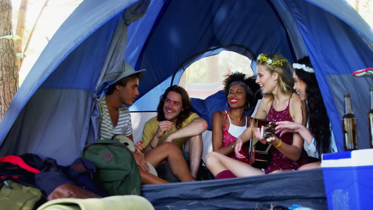 친구들이 텐트 4k에서 노래를 부르고 기타를 연주합니다.