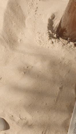 Vertical-Video-Summer-Holiday-Concept-Of-Sunglasses-Book-And-Cold-Beer-On-Beach-Towel-On-Sand