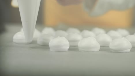primer plano de una crema de clara de huevo batida colocada por un chef con una bolsa de hielo en una placa de respaldo para hacer merengue
