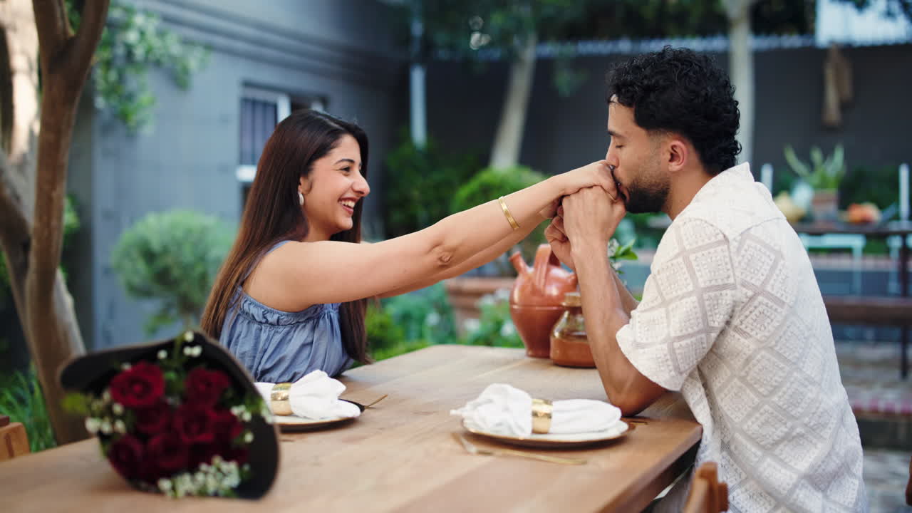 Man Kisses Woman's Hand During Romantic Outdoor Date