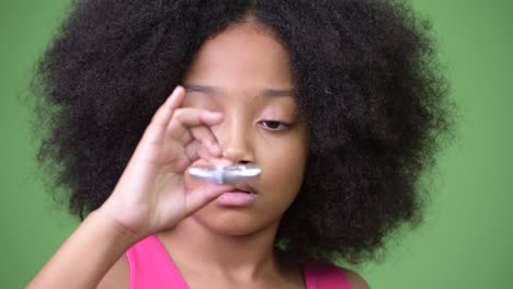 joven chica africana con cabello afro jugando con el girador inquietante