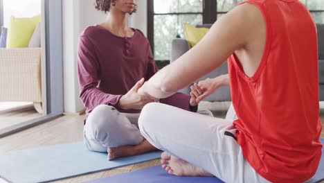 feliz pareja de hombres diversos haciendo yoga, meditando en la sala de estar