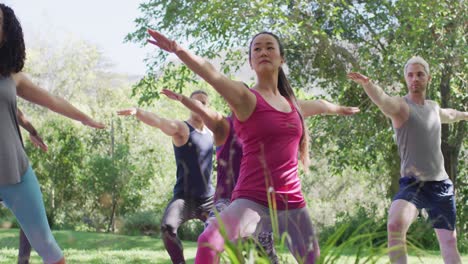 group of diverse young people meditating and practicing yoga together at the park