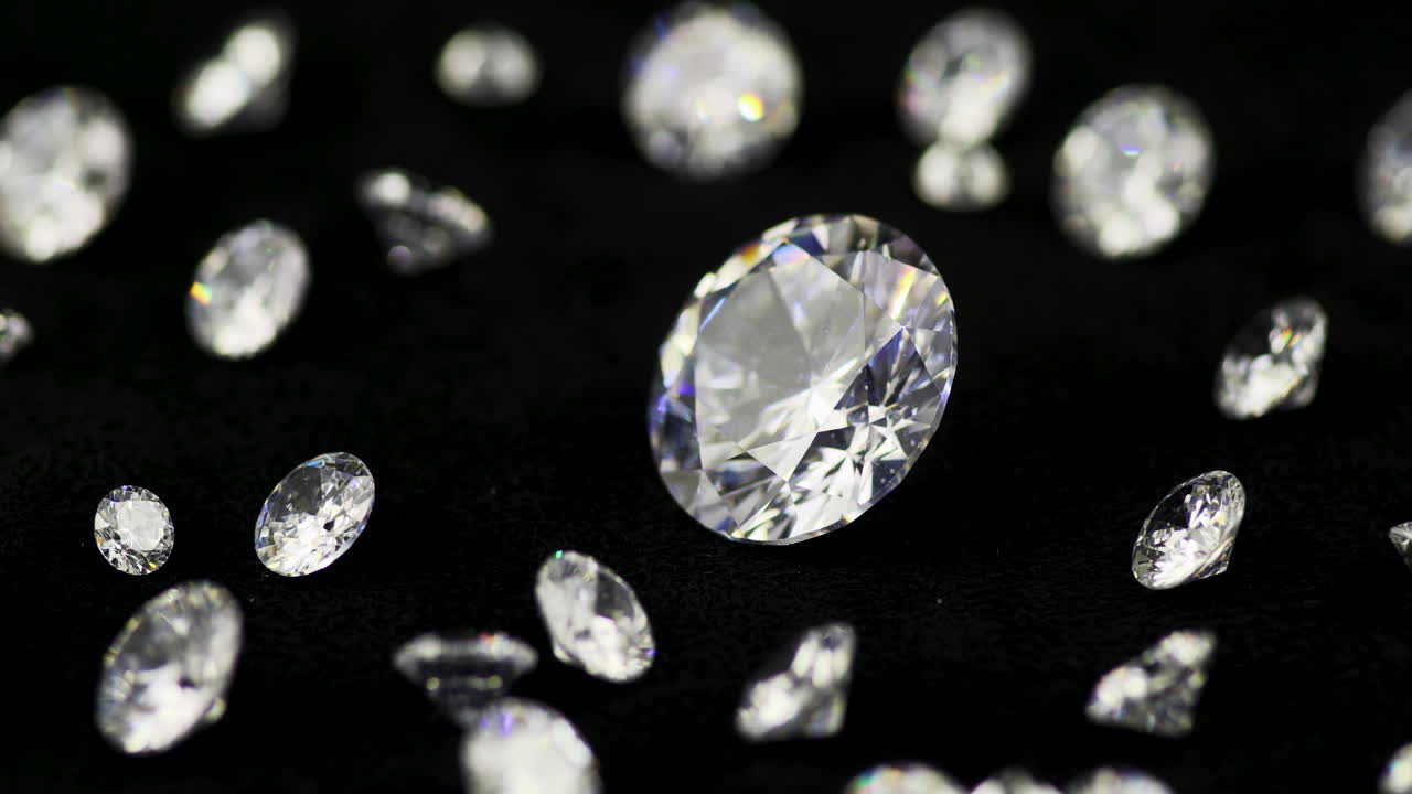 반시계 방향으로 회전하는 턴테이블에 있는 다양한 크기의 빛나는 다이아몬드 - 패션과 결혼식을 위한 매우 귀중하고 값비싼 보석