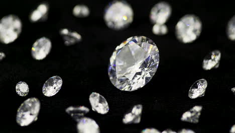 diamantes reales de corte brillante de varios tamaños en el plato giratorio girando en sentido antihorario primer plano dof bajo - piedras preciosas muy valiosas y caras para la moda y las bodas