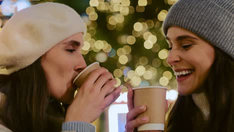 close up video of women drinking mulled wine at night.