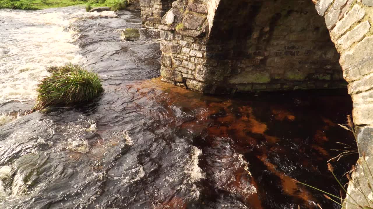 vista de puentes de piedra áspera en medio del parque nacional en el campo inglés con un arroyo debajo