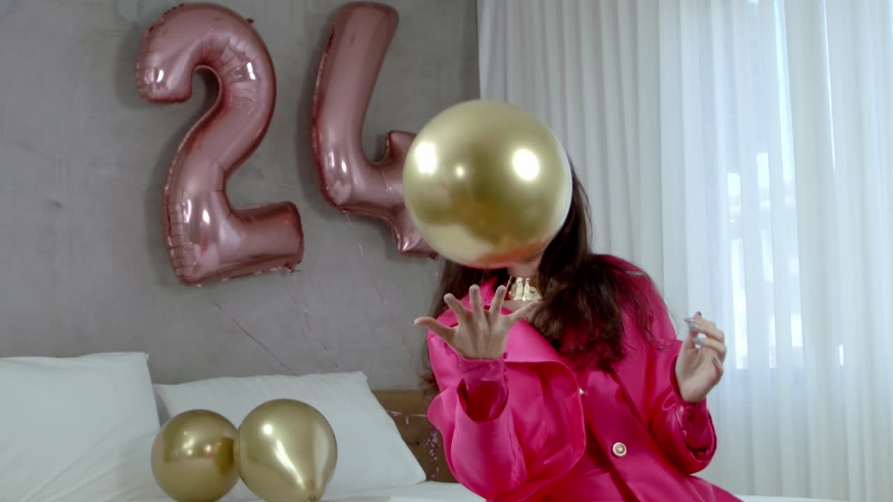 una joven lucha por contener el deleite del globo de cumpleaños.