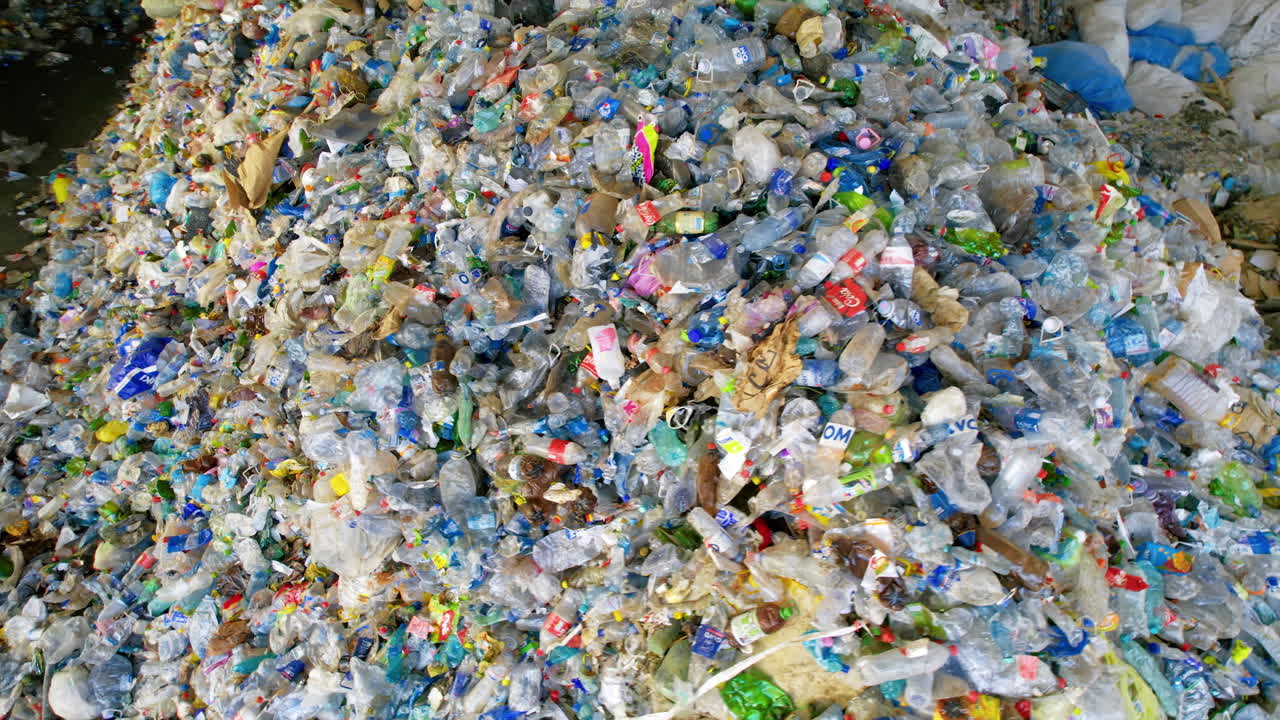 CHISINAU, MOLDOVA - MARCH 10 2023: Plastic trash heaps at a sorting plant, slow motion drone view