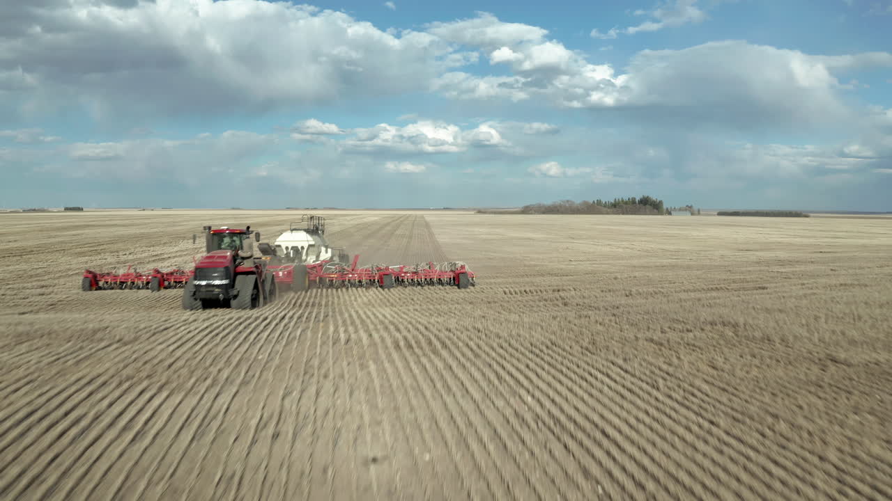 maquinaria de siembra en la amplia granja en saskatchewan, canadá en un clima brillante - disparo rápido de drones