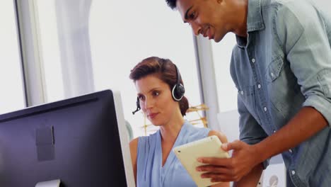 ejecutivos interactuando mientras trabajan en computadoras y tabletas digitales 4k