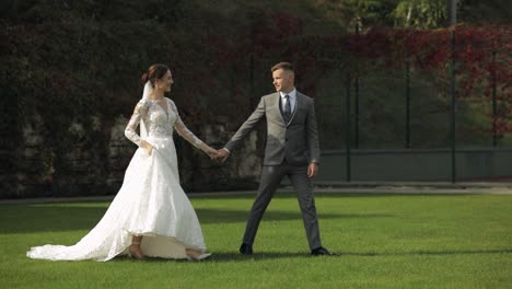 Lovely-newlyweds-caucasian-bride-groom-walking-in-park,-holding-hands,-wedding-couple-family