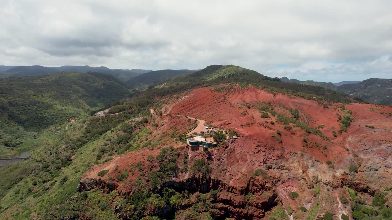 drone spin muestra el mirador de abrante y las rocas rojas en medio de las verdes montañas en la isla de la gomera, españa