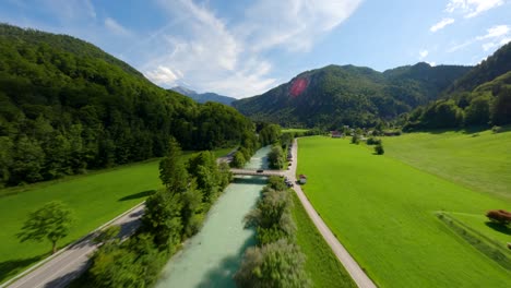 fpv drone flying over a river with turquoise water in the green mountains of austria