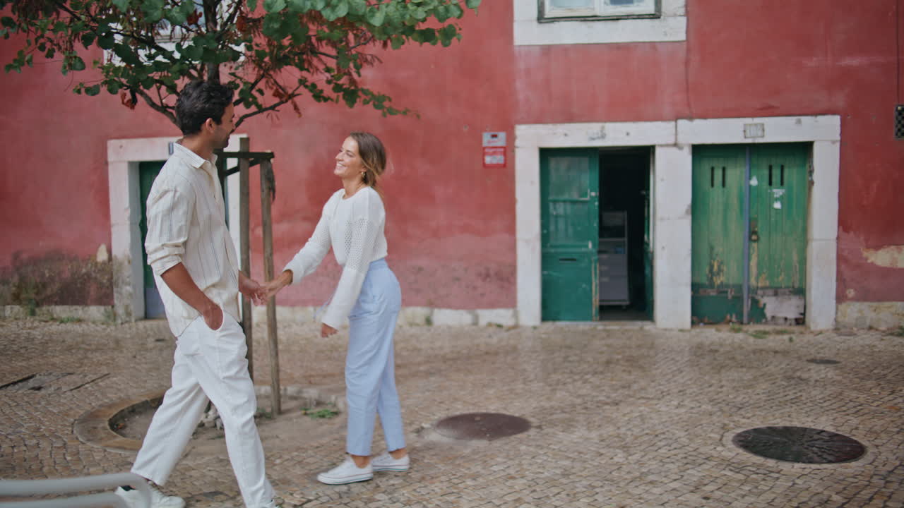 Two lovers holding hands walking paving stones city. Pair feeling happy resting