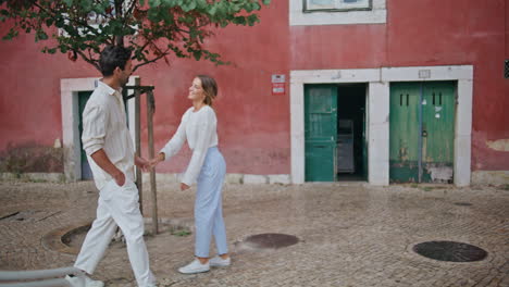 dos amantes tomados de la mano caminando pavimentando piedras ciudad. pareja sintiéndose feliz descansando