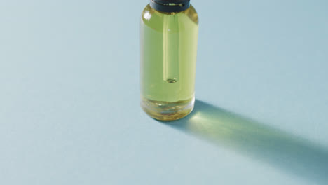 close up of glass bottle with pump with copy space on blue background