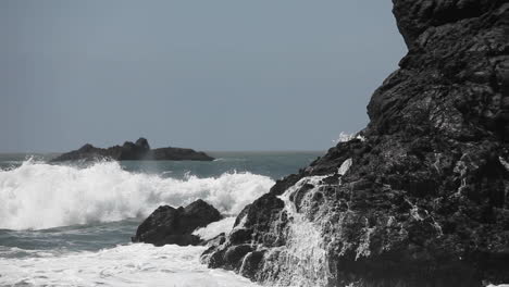 ocean waves crash against boulders