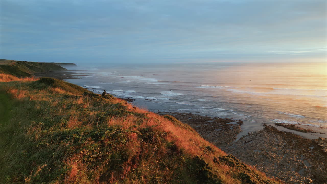 Lavtstigende etablerende droneoptagelse af Cleveland Way i Scarborough en tåget morgen ved gylden time
