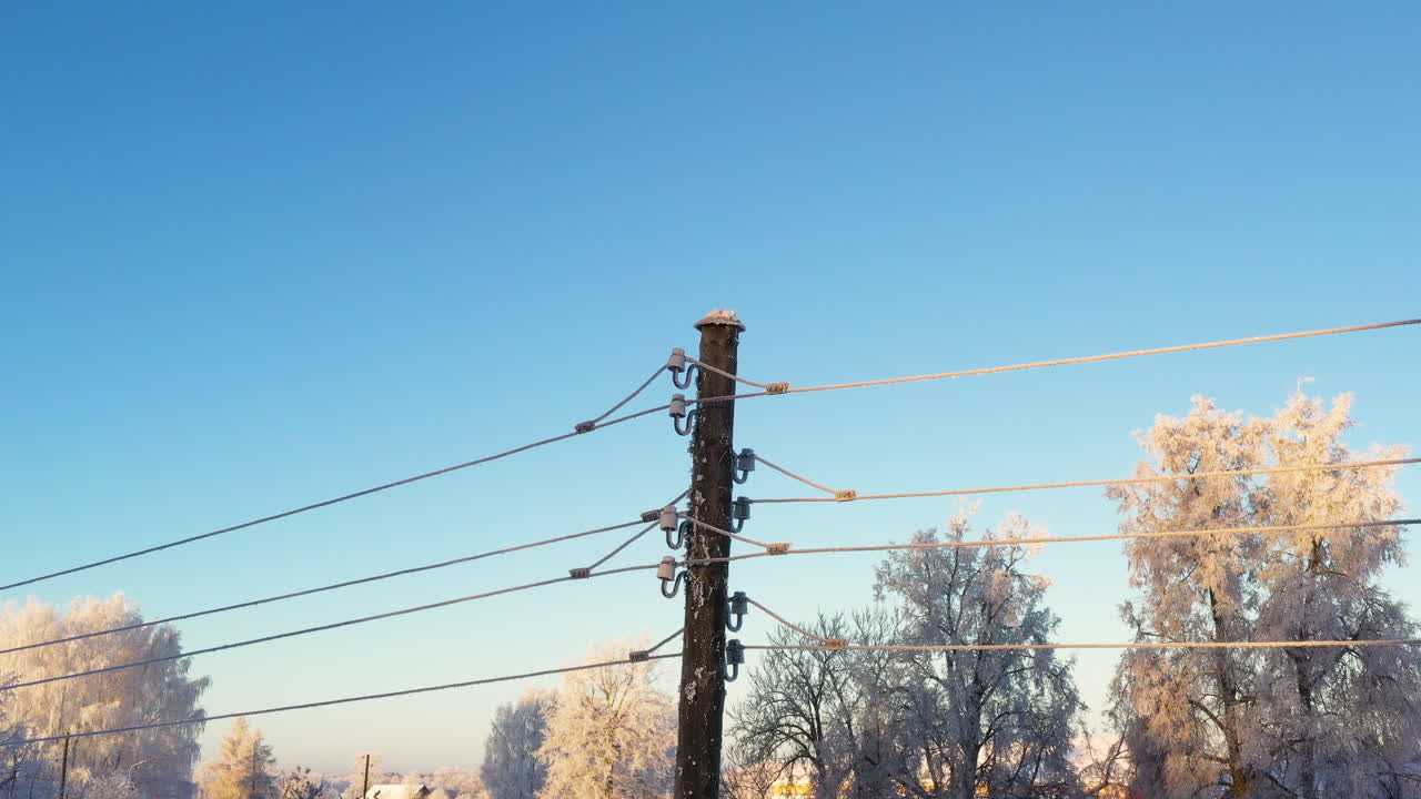 cables eléctricos cubiertos de hielo con fondo de cielo azul y espacio para texto