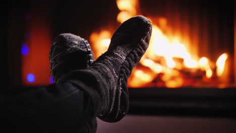 Legs-In-Socks-Near-The-Fireplace-Where-The-Fire-Burns-Evening-By-The-Fire