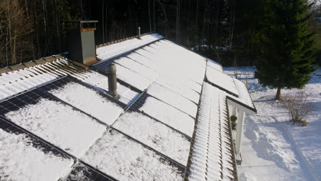 aerial view of the sun melting a snowy photovoltaic system on a house, winter day