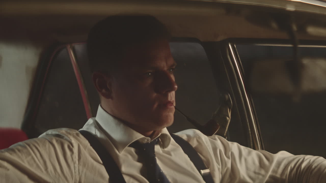 밤에 빈티지 자동차를 운전하는 남자