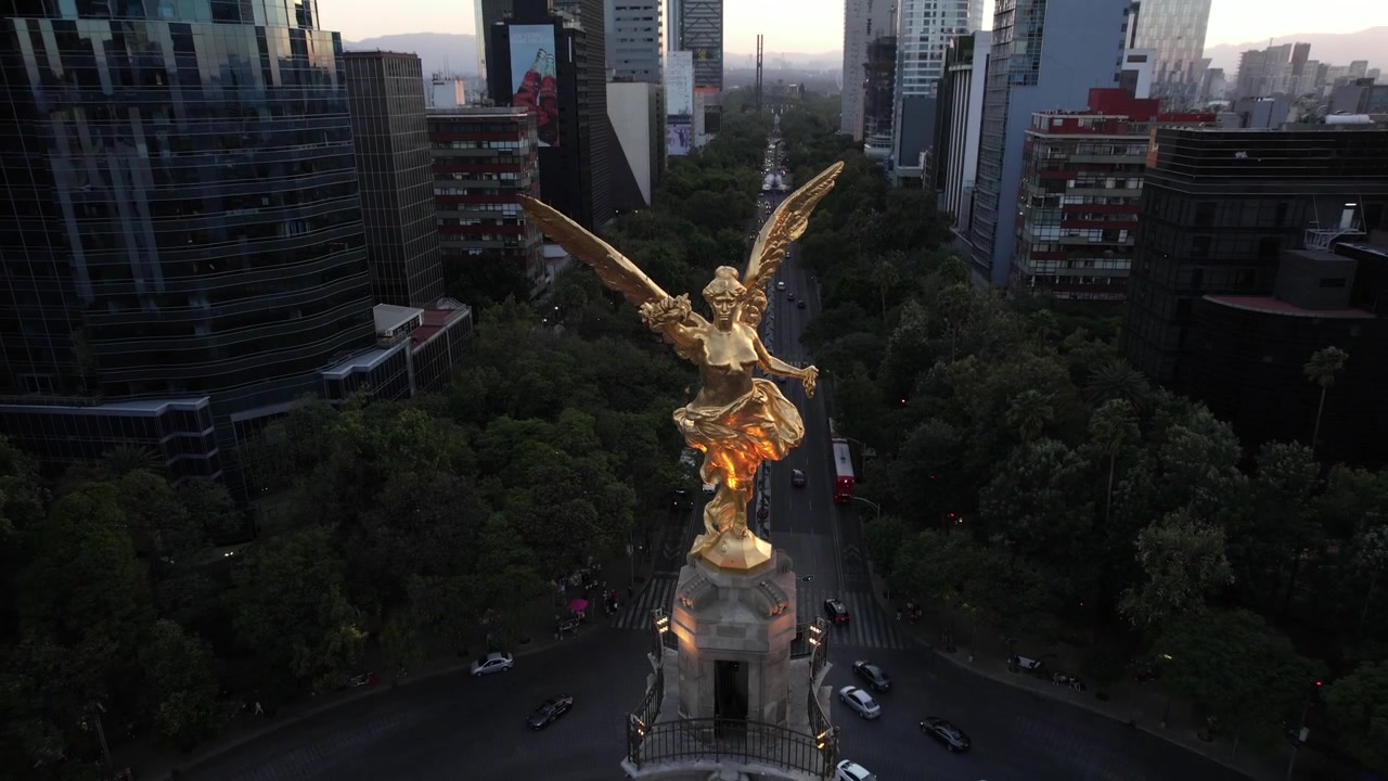 Meksika Şehri'ndeki Bağımsızlık Meleği anıtının etrafında yükselen sinematik hava drone çekimi. Kamera yavaşça ikonik Paseo de la Reforma caddesini, çevredeki gökdelenleri, şehir trafiğini ortaya çıkarıyor