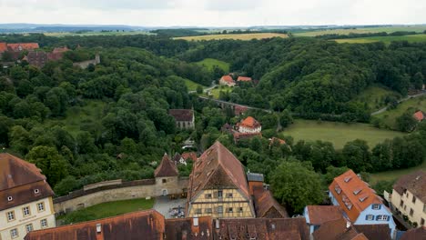 video aéreo de 4k de la antigua iglesia católica y el doble puente a lo largo del río tauber fuera de la ciudad amurallada de rothenburg, alemania