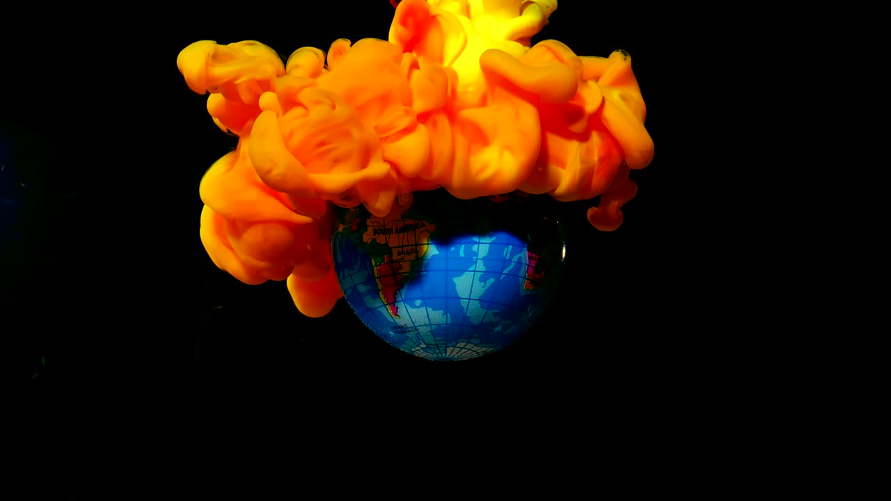 планета земля в огне. желтый и оранжевый акварельные чернила в воде на черном фоне